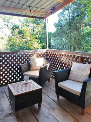 a porch with two chairs and a table on a deck at Cabaña Lugar de paz in Villa Mills