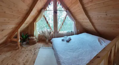 a bed in a wooden room with a window at Cabaña Lugar de paz in Villa Mills