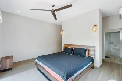 a bedroom with a bed and a ceiling fan at Villa with Minimalist Design & Scenic Deck with Private Infinity Pool and Jungle Views in Coco