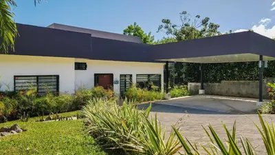 a large white building with a black roof at Villa with Minimalist Design & Scenic Deck with Private Infinity Pool and Jungle Views in Coco