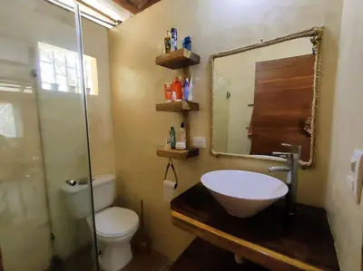 a bathroom with a sink and a toilet and a mirror at Casa Paraíso in Manzanillo