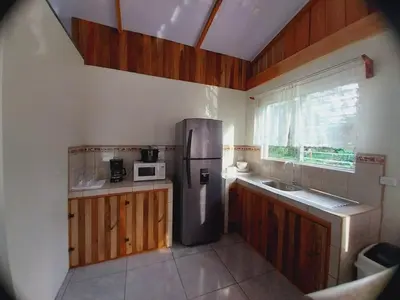 a kitchen with a stainless steel refrigerator and a microwave at Escapadita Pura Vida in Fortuna