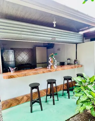 a bar with three stools in front of a counter at Casa Grande Villas Ela en Bahía Ballena in Uvita