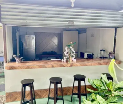 a kitchen with three bar stools in front of a counter at Casa Grande Villas Ela en Bahía Ballena in Uvita