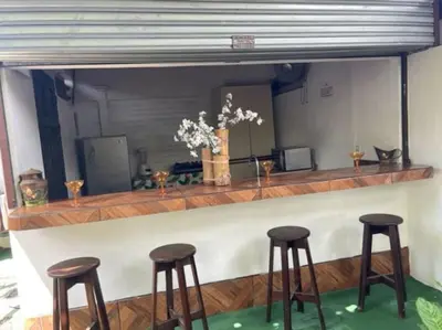 a bar with four brown stools at a counter at Casa Grande Villas Ela en Bahía Ballena in Uvita