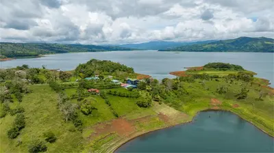 an island in the middle of a body of water at Tinajas Arenal Lakefront Lodge in Nuevo Arenal