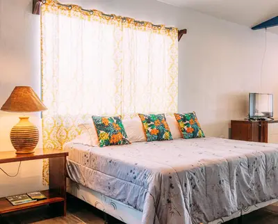 a bedroom with a bed with a window at Tinajas Arenal Lakefront Lodge in Nuevo Arenal