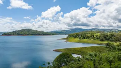 a view of a large body of water with trees at Tinajas Arenal Lakefront Lodge in Nuevo Arenal