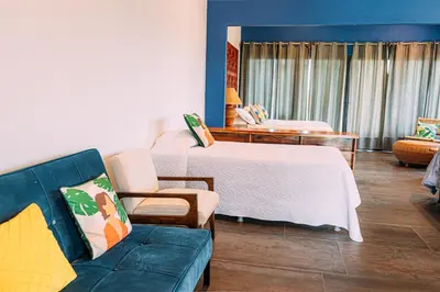 a hotel room with a bed and a couch at Tinajas Arenal Lakefront Lodge in Nuevo Arenal