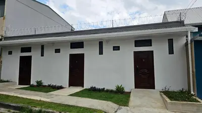 a white house with two doors and grass at BnB Ecostay in San José