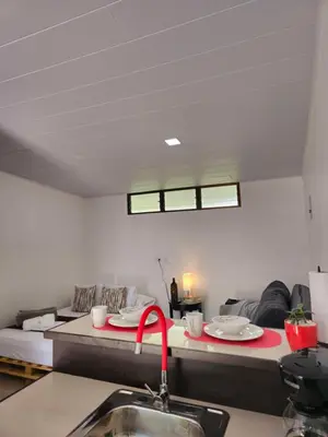 a kitchen with a sink and a living room at BnB Ecostay in San José