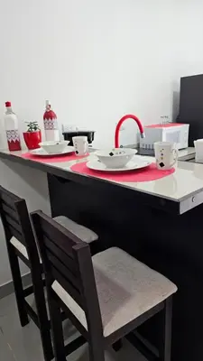 a kitchen with a red counter with two chairs and a sink at BnB Ecostay in San José