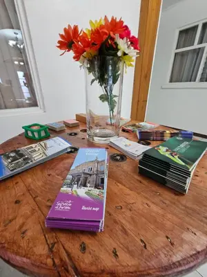 a wooden table with a vase of flowers and magazines at BnB Ecostay in San José