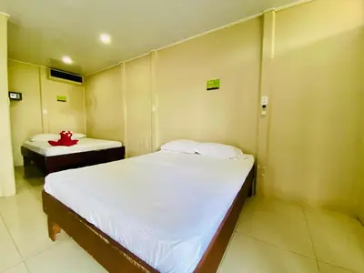 a small room with two beds and a table at Cabinas Arenal Home in Tanque