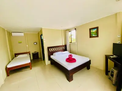 a room with a bed with a red item on it at Cabinas Arenal Home in Tanque