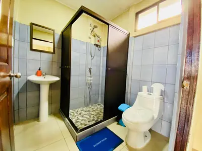 a bathroom with a shower and a toilet and a sink at Cabinas Arenal Home in Tanque
