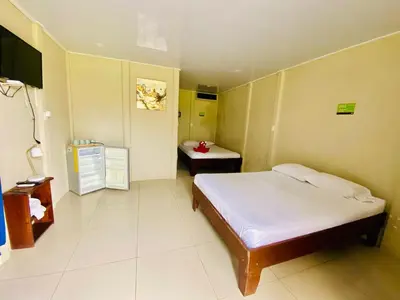 a bedroom with a bed and a table in it at Cabinas Arenal Home in Tanque