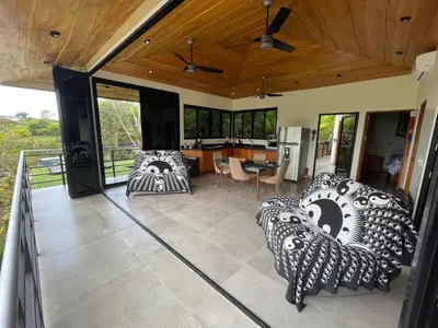 a living room with two couches and a kitchen at Villas Pura Vida in Ojochal