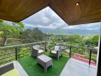 a balcony with chairs and a view of the mountains at Villas Pura Vida in Ojochal