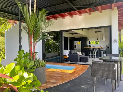 an outdoor living room with a table and chairs at Villas Pura Vida in Ojochal