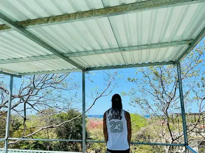 a person looking out of a window at the view at Olas de Oro in Nicoya