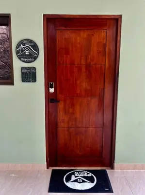 a wooden door with a mat in front of it at Casita Oropéndola in Monterrey