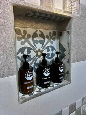 three bottles of soap on a shelf in a bathroom at Casita Oropéndola in Monterrey
