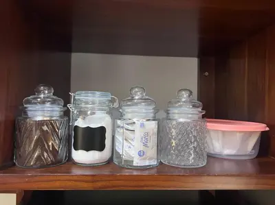 four glass jars sitting on a wooden shelf at Casita Oropéndola in Monterrey