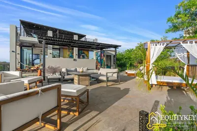 a patio with couches and tables and a building at Casa Luna Amarillo - Your Pacific Escape! in Playa Hermosa
