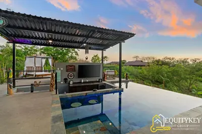 a house with a pool and a pergola at Casa Luna Amarillo - Your Pacific Escape! in Playa Hermosa