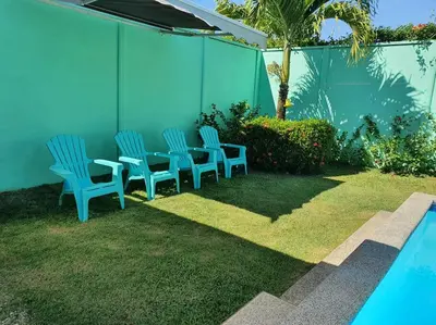 a patio with chairs and a table next to a pool at Casa Las Palmas Playa Bejuco in Bejuco