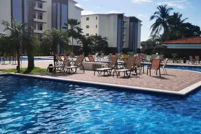 a pool with chairs and a table next to a building at Casa Las Palmas Playa Bejuco in Bejuco