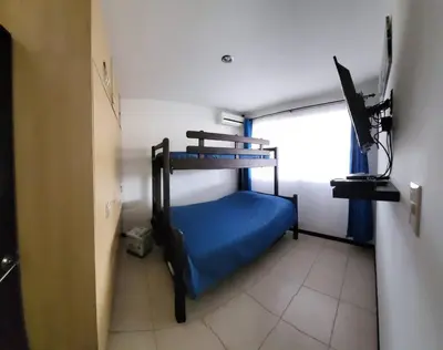 a small room with a bunk bed and a television at Casa Las Palmas Playa Bejuco in Bejuco