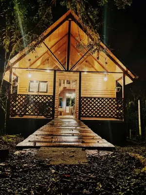 a wooden boardwalk leading to a house at night at Cabaña Lugar de Paz in División