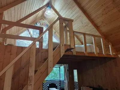 a loft in a wooden house with a staircase at Cabaña Lugar de Paz in División
