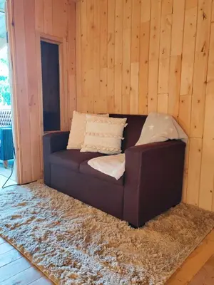 a brown couch sitting in a room with a rug at Cabaña Lugar de Paz in División