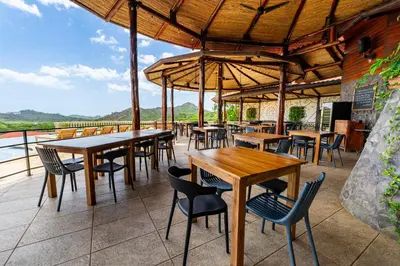 a restaurant with tables and chairs on a patio at Casa Rebanada De Vida in Brasilito