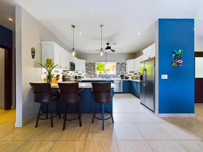 a kitchen with a blue island with bar stools at Casa Rebanada De Vida in Brasilito