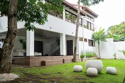 a white house with two white chairs in the yard at home 333 loft 334 in Escazu