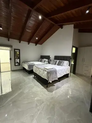two beds in a large room with marble floors at home 333 habitacion 335 in Escazu