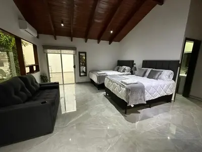 two beds in a room with a couch and a living room at home 333 habitacion 335 in Escazu
