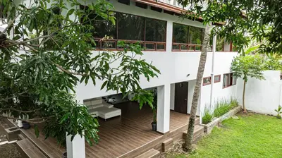a white house with a wooden deck with a bench at Home 333 habitacion 336 in Escazu