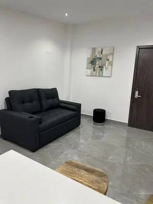a black couch sitting in a living room at home 333 habitacion 337 in Escazu