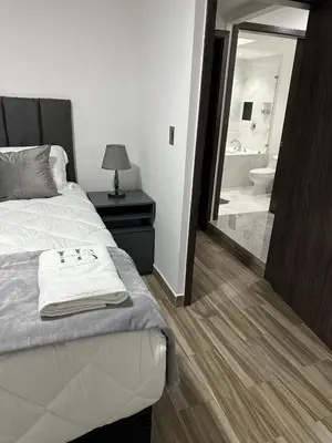 a bedroom with a bed and a bathroom with a mirror at home 333 habitacion 337 in Escazu