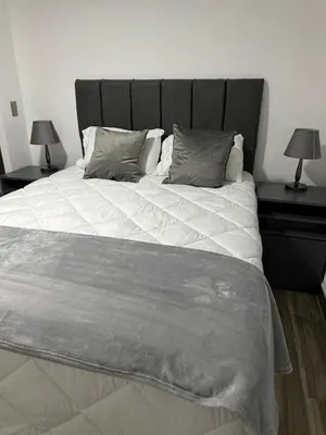 a bedroom with a large bed with two end tables at home 333 habitacion 337 in Escazu