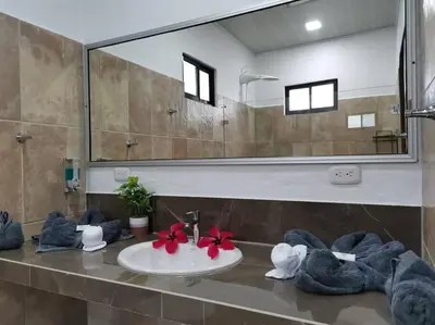 a bathroom with a sink with towels and a mirror at Susan Bungalow#1 Bahía Drake, Corcovado Familia Amaya in San Pedrillo