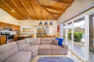 a living room with a couch and a kitchen at Beautiful 2-BR House Steps from the Beach in Playa Flamingo
