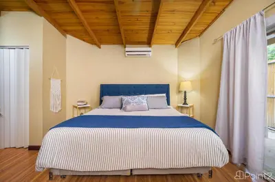 a bedroom with a large bed with a blue and white blanket at Beautiful 2-BR House Steps from the Beach in Playa Flamingo