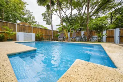 a swimming pool with blue water in a yard at Beautiful 2-BR House Steps from the Beach in Playa Flamingo