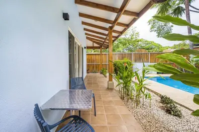 a patio with a table and chairs and a swimming pool at Beautiful 2-BR House Steps from the Beach in Playa Flamingo